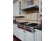 A modern kitchen highlights a professional-grade range, custom cabinets, and sleek countertops at 8171 E 33Rd Ave, Denver, CO 80238