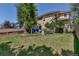 Expansive backyard featuring a well-maintained lawn, mature trees, and garden beds, ideal for relaxation at 10609 Abilene St, Commerce City, CO 80022