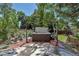 Backyard featuring a private hot tub nestled in a serene, tree-filled setting with mature landscaping at 10609 Abilene St, Commerce City, CO 80022