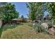 Lush backyard with mature trees, a charming patio area, and plenty of space for outdoor activities at 10609 Abilene St, Commerce City, CO 80022