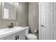Neutral-toned powder room with a modern vanity, white toilet, and decorative mirror at 10609 Abilene St, Commerce City, CO 80022