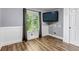 Cozy bedroom with hardwood floors, a mounted TV, and a window with natural light at 10609 Abilene St, Commerce City, CO 80022