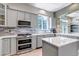 Modern kitchen featuring stainless steel appliances, gray cabinetry and a bright, window-lit space at 10609 Abilene St, Commerce City, CO 80022
