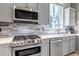 Modern kitchen featuring stainless steel appliances, gray cabinets, and a stylish backsplash at 10609 Abilene St, Commerce City, CO 80022