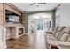 Bright living room with a stone fireplace, wood accent wall, and open layout to the kitchen and dining areas at 10609 Abilene St, Commerce City, CO 80022