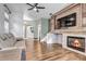 Inviting living room showcases a stone fireplace, wood accent wall, and hardwood floors at 10609 Abilene St, Commerce City, CO 80022