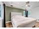 Bright main bedroom features a tray ceiling, neutral colors, ceiling fan, and wood-look floors at 10609 Abilene St, Commerce City, CO 80022