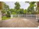 Large backyard deck with white railing overlooking the yard and mature trees at 6072 Pierson Ct, Arvada, CO 80004