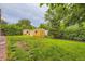 Spacious backyard with a shed, lush green lawn, and mature trees offering privacy at 6072 Pierson Ct, Arvada, CO 80004