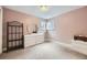 Cozy bedroom features soft pink walls, carpet floors, and a corner window at 6072 Pierson Ct, Arvada, CO 80004