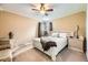 Bedroom featuring tan walls, carpet floors, ceiling fan, and side tables at 6072 Pierson Ct, Arvada, CO 80004