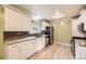 Bright kitchen featuring white cabinetry, hardwood floors, and ample countertop space at 6072 Pierson Ct, Arvada, CO 80004