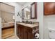 Bathroom featuring double sink vanity with granite counters, dark wood cabinets and tile accents at 3298 S Krameria St, Denver, CO 80222
