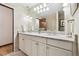 Bright bathroom featuring a double sink vanity, large mirror, and decorative lighting at 3298 S Krameria St, Denver, CO 80222