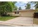 Traditional home exterior featuring a green lawn, mature trees, and an attached two car garage at 3298 S Krameria St, Denver, CO 80222
