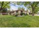 Traditional home exterior featuring a green lawn, mature trees, and an attached two car garage at 3298 S Krameria St, Denver, CO 80222