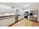 Bright kitchen features white cabinets, stainless steel appliances, and lots of natural light at 3298 S Krameria St, Denver, CO 80222