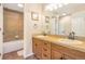 Double sink bathroom with granite countertops, tan tile, and a tub/shower for a practical layout at 15723 E Orchard Pl, Aurora, CO 80016