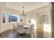 Elegant dining room with chandelier, hardwood floors, and views of the backyard at 15723 E Orchard Pl, Aurora, CO 80016