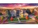 Beautiful home with a well-maintained lawn, mature trees, and a colorful sunset backdrop at 15723 E Orchard Pl, Aurora, CO 80016