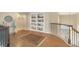 Second-floor landing featuring wood floors, a decorative rug, and built-in shelving at 15723 E Orchard Pl, Aurora, CO 80016