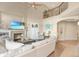 Bright living room with a cozy fireplace, a large white sofa, and a ceiling fan at 15723 E Orchard Pl, Aurora, CO 80016