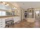 Expansive bathroom featuring dual sinks, a vanity area, tiled floors, and a glass enclosed shower at 15723 E Orchard Pl, Aurora, CO 80016