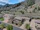 Aerial view of a luxury home in a mountainous neighborhood with mature trees at 5951 Rain Dance Trl, Littleton, CO 80125