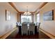 Elegant dining room featuring a modern chandelier, large windows, and seating for eight guests at 5951 Rain Dance Trl, Littleton, CO 80125
