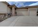 Exterior front view of a two-car garage, concrete driveway and stone entrance columns at 5951 Rain Dance Trl, Littleton, CO 80125