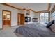 View of the primary bedroom showing a fireplace, balcony access, and adjoining bathroom at 5951 Rain Dance Trl, Littleton, CO 80125