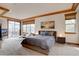 The large main bedroom suite is bright with balcony access and elegant ceiling detail at 5951 Rain Dance Trl, Littleton, CO 80125