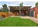 Inviting backyard features a wooden pergola, a sauna, and lush green lawn for relaxation and entertainment at 3237 N Josephine St, Denver, CO 80205