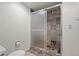 Bathroom featuring tiled shower with glass doors, toilet and tiled floor at 7761 S Curtice Dr # C, Littleton, CO 80120