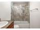 Bathroom featuring marble tile shower with glass doors, and toilet at 7761 S Curtice Dr # C, Littleton, CO 80120