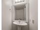 Elegant powder room with pedestal sink and decorative mirror, adding a touch of sophistication at 7761 S Curtice Dr # C, Littleton, CO 80120