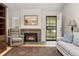 Warm living room featuring a fireplace, tile hearth, hardwood floors, and a cozy sitting area at 7761 S Curtice Dr # C, Littleton, CO 80120