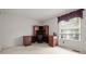 Office space with large wooden built-in desk and storage, window with blinds, and neutral carpet at 7761 S Curtice Dr # C, Littleton, CO 80120