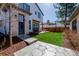 A charming backyard with a stone patio, lush green lawn, and modern exterior details at 2365 S Clayton St, Denver, CO 80210