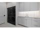 Modern laundry room featuring stainless steel washer and dryer, grey cabinetry, and stone countertop at 2365 S Clayton St, Denver, CO 80210