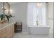 Elegant bathroom featuring double sinks, soaking tub, marble floors, and a modern light fixture at 2365 S Clayton St, Denver, CO 80210