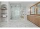 Spacious bathroom with double sinks, glass enclosed shower, marble floors, and built-in shelving at 2365 S Clayton St, Denver, CO 80210