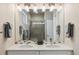Elegant bathroom featuring double sinks, a large mirror, and a stylish tiled shower at 763 Sage Forest Ln, Monument, CO 80132