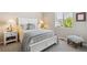 Cozy bedroom features a plush bed with light blue accents, bright natural light, and a comfy bench at 763 Sage Forest Ln, Monument, CO 80132