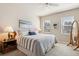 Bright bedroom with striped bedding, bedside table, and windows offering natural light at 763 Sage Forest Ln, Monument, CO 80132