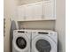 Functional laundry room with white cabinets and modern side-by-side washer and dryer at 763 Sage Forest Ln, Monument, CO 80132