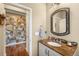 Stylish half bathroom features a decorative mirror, granite countertop, and a doorway to the adjacent room at 10057 Des Moines St, Parker, CO 80134