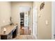 Hallway with light wood flooring, built-in desk, and access to the kitchen with stainless steel appliances at 10057 Des Moines St, Parker, CO 80134