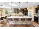 Modern kitchen with a large island, granite countertops, dark cabinetry, hardwood floors, and stainless steel appliances at 10057 Des Moines St, Parker, CO 80134