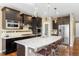 Modern kitchen with stainless steel appliances, a large island, and dark cabinetry with light countertops at 10057 Des Moines St, Parker, CO 80134